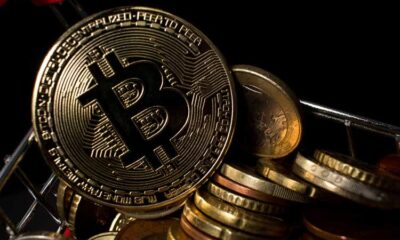 Closeup of bitcoin coin in a shopping cart with euro coins. BTC coin with dark background.