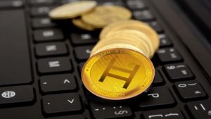 Conceptual tokens for Hedera Hashgraph (HBAR) on a black keyboard.