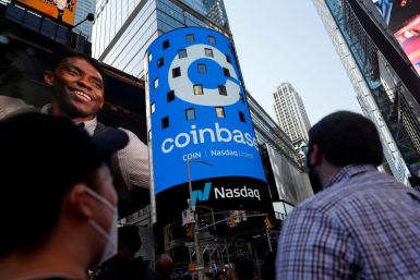 People look at the logo of Coinbase Global Inc, the largest cryptocurrency exchange in the United States, displayed on the jumbotron of the Nasdaq MarketSite in Times Square in New York